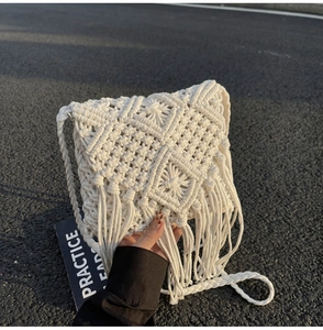 Detalle del bolso bandolera bohemio de algodón crema tejido a mano con flecos largos