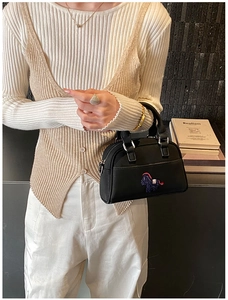 Détail de la texture cuir noir de haute qualité et broderie cheval sur le sac à main