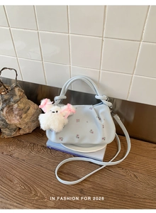 Detail of floral dumpling bag with detachable strap and white plush toy pendant