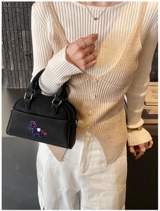 Détail du sac bowling en cuir noir avec broderie de cheval bleu et poignées robustes