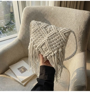 Primer plano de bolso bandolera de macramé blanco con textura geométrica y flecos largos