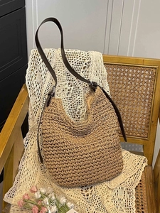 Woven straw tote bag with brown leather straps for beach holidays and casual style