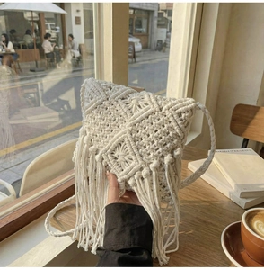 Primer plano de bolso de macramé de algodón con flecos bohemios y textura geométrica