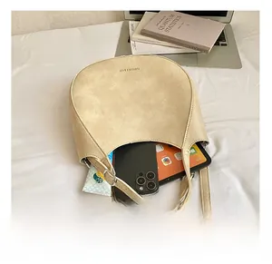 Detail view of spacious interior of the beige half-moon shoulder bag with daily items