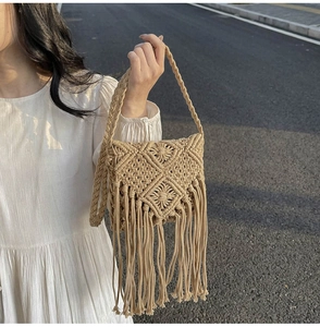 Detalle de bolso bohemio de paja tejida con motivos de diamantes y borlas largas suaves