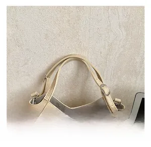 Detail showing the comfortable beige handbag handles with silver adjustable metal buckles