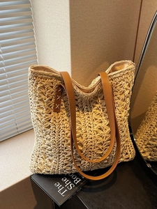Large woven tote bag with brown leather handles and zipper closure for beach holidays