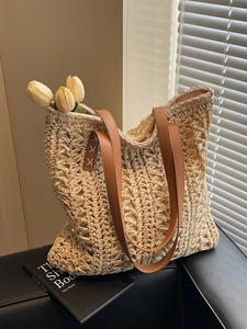 Woven tote bag with brown faux leather straps and cream crochet texture on a soft shadow background