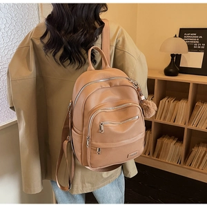 Lifestyle shot of camel pebbled leather backpack with silver hardware and large capacity