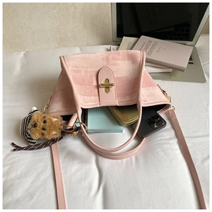Top view of pink canvas tote showing spacious interior with daily essentials and gold twist lock