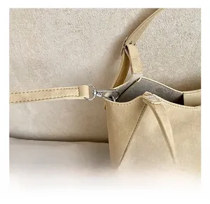 Close-up of premium metal hook and D-ring on beige faux leather bucket bag