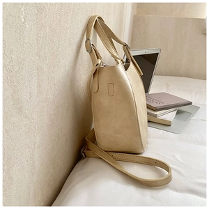 Detail of beige faux leather tote with silver buckle, adjustable strap and matte texture