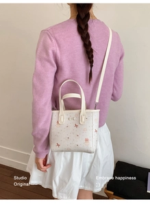 Detail of white mini tote bag with cute cat prints and adjustable shoulder strap