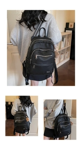 Detail of black PU leather backpack with arrow pattern straps and brown pompom charm