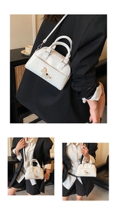 Détails d'un sac à main blanc en forme de coquille avec broderie poney et bandoulière