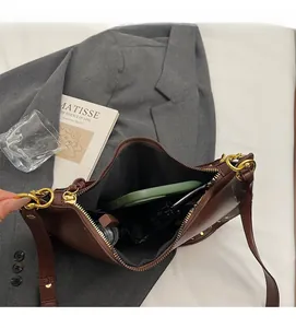 Top view of brown rivet crossbody bag interior showing spacious storage and dark lining