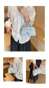 Détails du sac baguette en cuir bleu clair avec broderie de poney et texture grainée