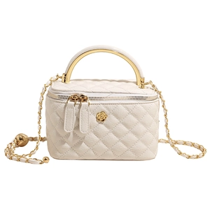 Close-up of beige quilted leather mini box bag with gold floral logo and chain strap