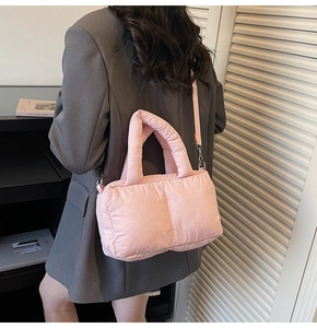 Detailed view of pink padded puffer tote bag with metallic hardware and long shoulder strap