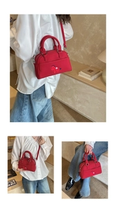 Détail du sac Boston rouge en tissu avec broderie cheval et bandoulière réglable