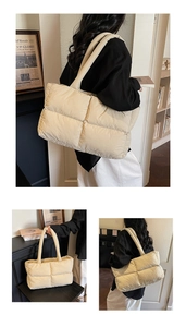 Detailed view of beige quilted puffer tote bag showing soft texture and wide shoulder strap