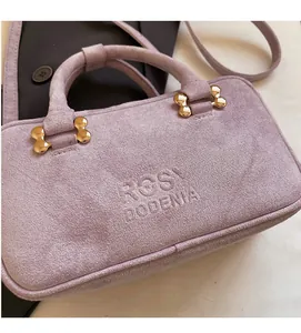Close-up of lilac suede baguette bag featuring gold buckle and Rosy Bodenia logo