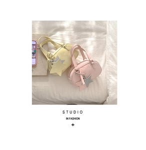 Detailed view of mini pleated PU leather bowling bags with decorative star pendants