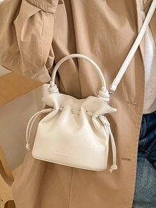 Sac seau blanc élégant avec cordon de serrage et poignée supérieure porté par un mannequin