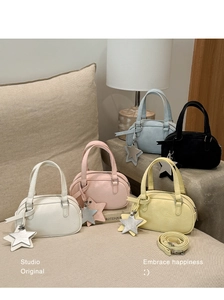 Five macaron-colored mini Boston bags in PU leather with star pendants on a cozy sofa
