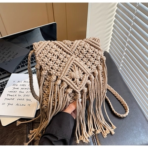 Primer plano detallado del patrón tejido bohemio y flecos largos en el bolso beige