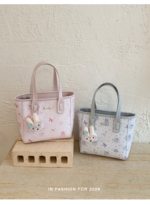 Detail of quilted tote bags with cute cartoon prints and plush bunny charms