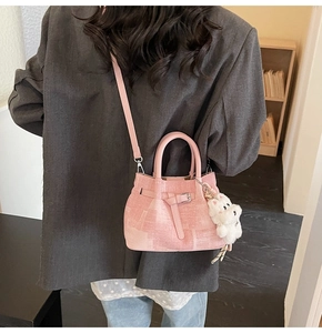 Rosa Faltenbeuteltasche mit Plüschanhänger kombiniert mit grauem Blazer für den Alltag