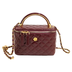 Quilted dark red patent leather mini vanity bag with chain strap and gold flower detail