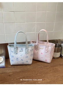 Detail of pleated textured tote bags with cute cartoon cat prints and bone pendants