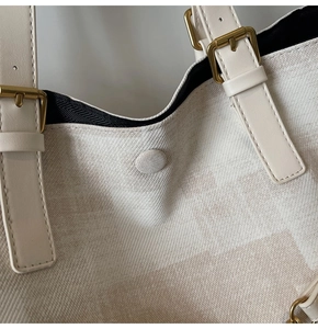 Detail view of checkered canvas tote bag showing magnetic closure and gold buckle