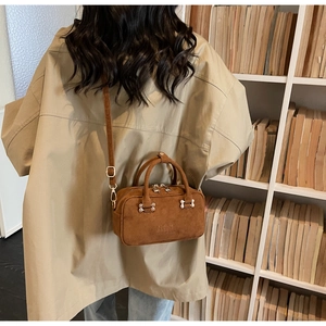 Brown suede-texture baguette bag shown from behind, highlighting the crossbody strap style