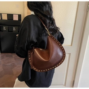 Vue arrière du sac cabas demi-lune marron avec rivets dorés sur base en cuir de qualité