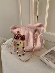 Pink quilted shoulder bag with gold chain strap and cute plush charm on white background
