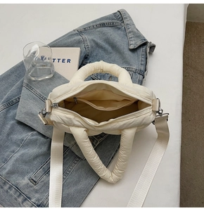 Detail view of cream white quilted puffer tote bag with spacious interior and zipper pocket