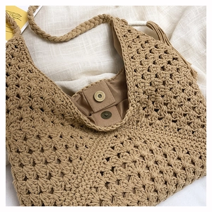 Close-up of woven tote bag with magnetic clasp detail and khaki crochet texture