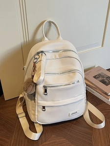 Minimalist white lychee leather backpack with multiple zip pockets and decorative pom-pom