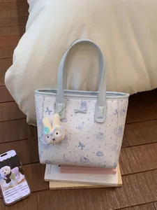 Cute light blue cartoon cat tote bag with rabbit plush charm on wooden floor