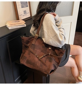 Detail of dark brown tote bag with geometric pattern and adjustable leather strap
