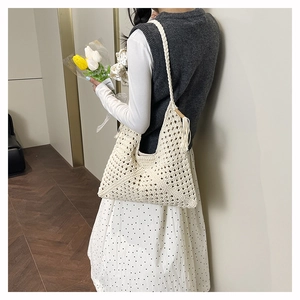 Detail of cream crochet tote bag featuring hollow diamond pattern and fringe tassel decor