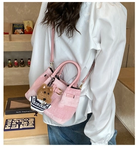 Detail der rosa Canvas Beuteltasche mit süßem braunem Plüsch-Hundeanhänger und goldener Hardware