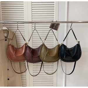 Close-up of four colored retro crescent bags with metal studs and tassel details