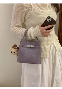Detail of lavender bucket bag with silver buckle and cute plush bear charm accessory