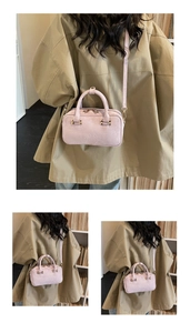 Detail of pink suede crossbody bag featuring embossed ROSY BODENIA logo and metal zipper