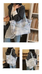 Detail of a large tote bag featuring geometric canvas texture and leather shoulder strap
