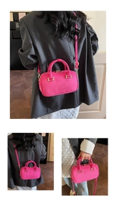 Detail view of rose pink suede mini bag with gold hardware and brand embossing